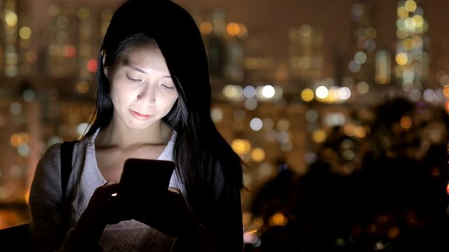 Woman working on cellphone at night
