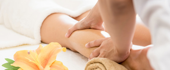 Professional therapist giving traditional thai oil massage to a woman in spa