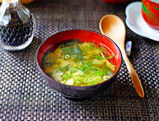 A bowl of miso soup (from above) on a dark background.