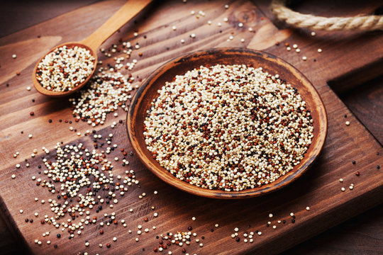 Mixed quinoa in bowl on wooden kitchen board.