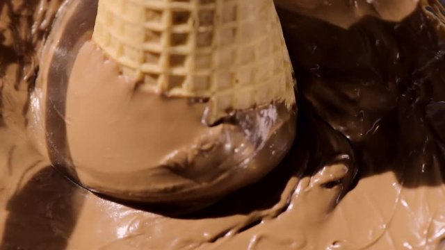 Woman Hand Dips A Sugar Cone Into A Bowl Of Chocolate, She Spins The Cone To Shake Off Excess Chocolate
