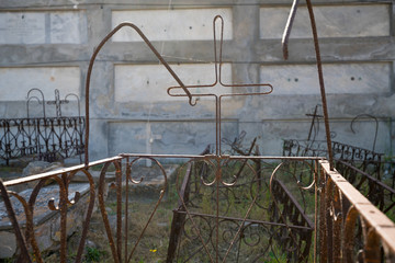 Minimalist latin cross on a wrought iron grave border