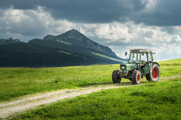Old tractor on meadow. Beautiful mountain view in the Alps