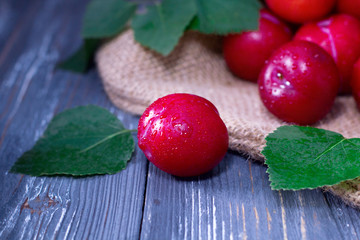 Red plums on wooden table
