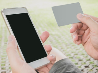 Men are making card payments using mobile apps for convenience, speed, and ease of ordering. While sitting play in the park ,concept you can place your order and make financial transactions anywhere.