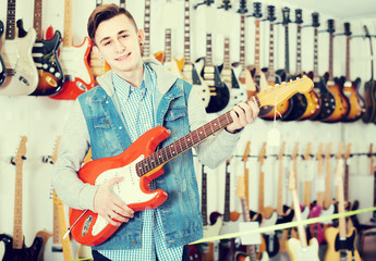 teenage customer deciding on suitable amp in guitar shop