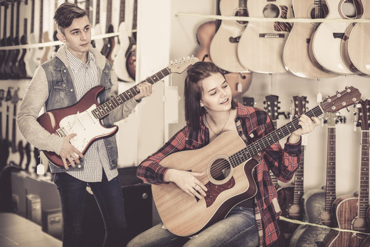 Female and male rock-n-roll players are choosing between acoustic and electric guitar