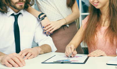 Young business team analise financial paper charts and graphs on the table.