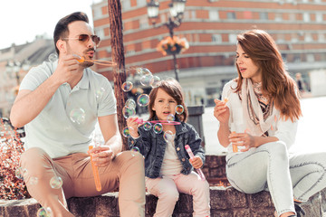Young parents playing with their little daughter