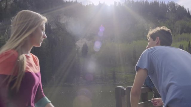 Group Of Friends Hang Out At Lake, Teenage Boy Twirls His Girlfriend, Then Skips Stones (Slow Motion) 