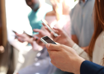 Group of students watching smartphones. Young people addiction to new technology trends.