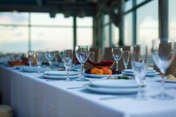 Sparkling glassware stands on long table prepared for wedding dinner