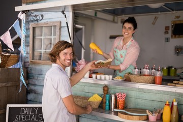 Smiling waitress giving wrap to customer at counter