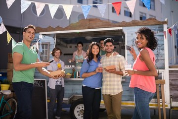 Happy friends standing with glasses of juice