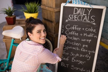 Portrait of waitress writing on slate