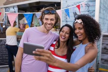 Happy friends taking selfie from mobile phone