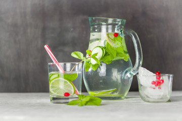 Water detox in a glass jar and a glass. Fresh green mint and berries. A refreshing and healthy drink.