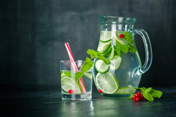 Water detox in a glass jar and a glass. Fresh green mint and berries. A refreshing and healthy drink.