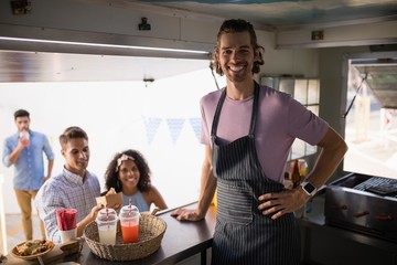 Customers and waiter standing at food truck counter - Powered by Adobe
