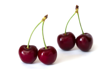 Two couple of sweet cherries isolated on white background