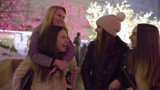 Happy Friends Walk Around Downtown, Lit For The Holidays, Blonde Jumps On Her Friend's Back For A Ride