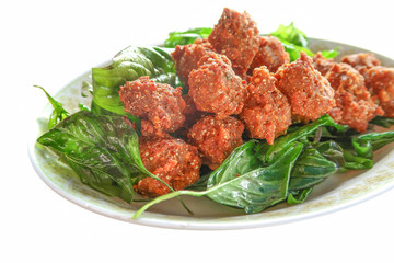 Fried pork minced balls with fried basil on white background