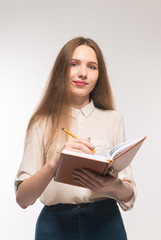 Young girl with pencil and book in hands