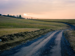 Backcountry dirt road, gravel path on foothills of lower tatras mountain in Slovakia at sunset time.
