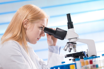 Doctor woman working  a microscope. Female scientist looking through a microscope in lab. Student girl looking in a microscope, science laboratory concept