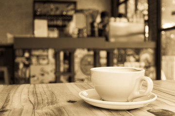 Empty coffee cup on wooden in coffee shop background, antique style