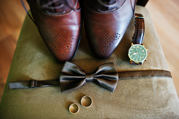 Groom's shoes, bow tie, rings and a watch for the wedding ceremony.