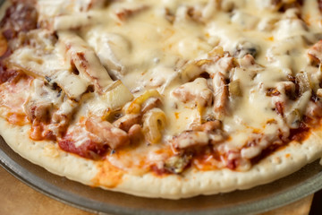 fresh homemade pizza on wooden board under sun rays