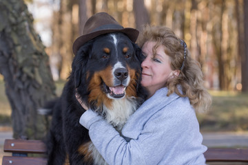 woman with bernese mountain dog on nature