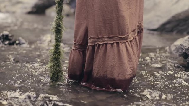 Young Woman Wades In Stream With Walking Stick, Walks Toward Camera, Slow Motion