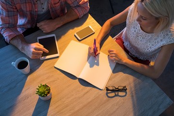 Female executive writing in diary during a meeting