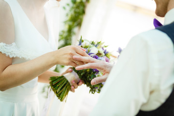 The bride and groom exchange rings during a wedding ceremony, a wedding in the summer garden