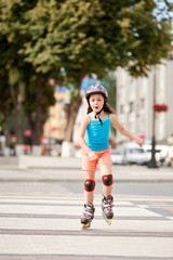 Obraz premium Cute little girl learning to roller skate outdoors on beautiful summer day