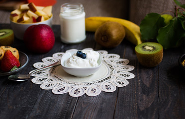Healthy breakfast, cereal with yogurt, strawberries, blueberry, apple, banana, on rustic wooden.  Top view