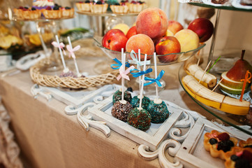 Gorgeous-looking wedding table with various beverages, delicious dishes, fruits and decorations.