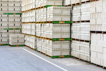 Piles of concrete blocks on wooden pallets stacked outdoors.