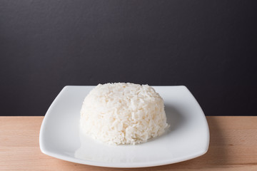 Steamed rice on white plate wood background