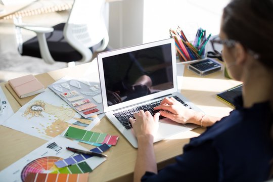 Female executive working over laptop at her desk