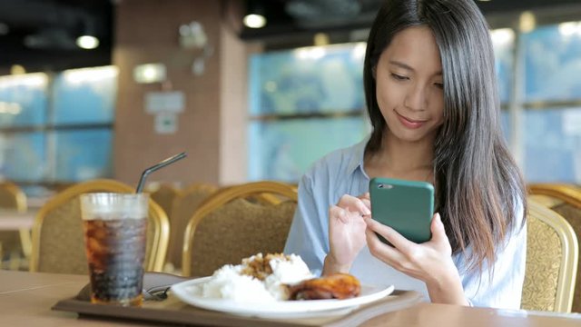 Woman looking at the mobile phone in restaurant