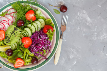 Bright summer salad of vegetables and berries. Love for a healthy vegan food concept.