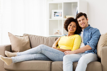 Obraz premium happy smiling international couple on sofa at home