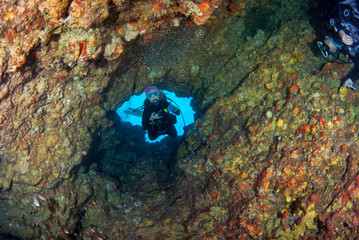 Fototapeta na wymiar Young woman scuba diving in cave at South Andaman, Thailand