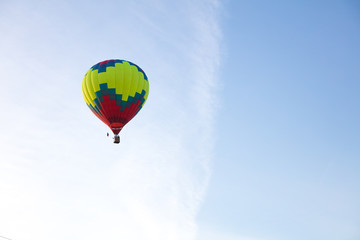Bright aerostat in cloudy blue sky