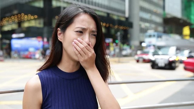Woman sneezing and coughing at outdoor