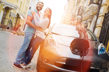 Adorable young couple hugging near the car