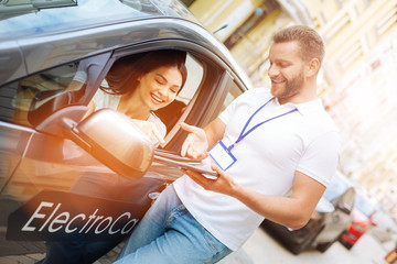 Smiling woman listening to car rental agency employee